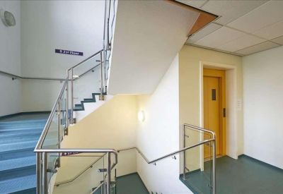 Bright multi-level staircase with metal railings and blue carpeted steps.