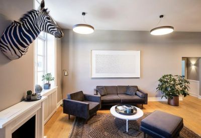 Lounge area featuring a zebra head wall mount, grey sofas, and a white coffee table.