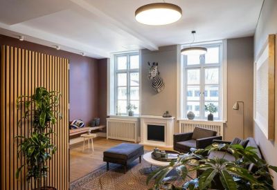Cozy seating area with a white fireplace and large windows letting in natural light.