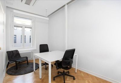 Private office for two with white desks and light wood parquet flooring.