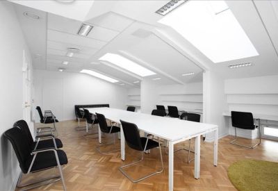 Large open-plan attic workspace with multiple desks and bright skylights.