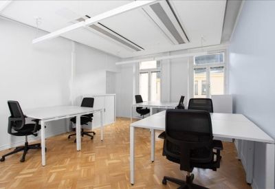 Bright two-person office suite with minimalist white furniture and large windows.