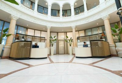 Bright circular lobby with marble floors and reception desks.