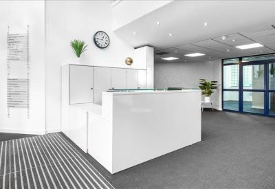 Minimalist white reception desk in a bright, professional lobby area.