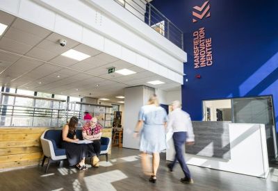 Modern lobby with a reception desk and a prominent blue feature wall with branding.
