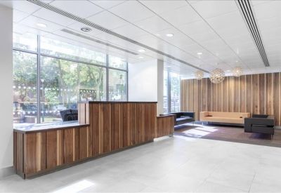 Bright reception area featuring a warm wood-slat desk and matching feature wall.