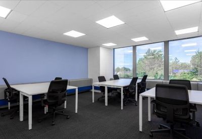 Spacious open-plan workspace with six desks and a blue feature wall.
