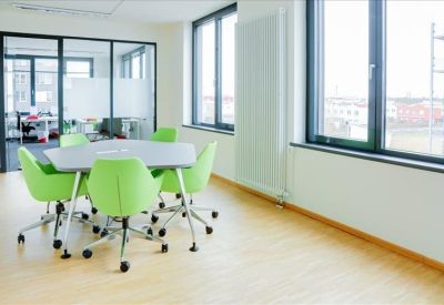 Contemporary breakout area with a white dining table and high-backed orange privacy booths.