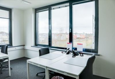 Modern conference room with a large white oval table and grey seating.