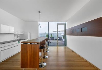 Modern kitchen and break area with a wooden breakfast bar and balcony access.