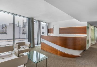 Elegant reception area featuring a curved wood-panelled front desk and city views.