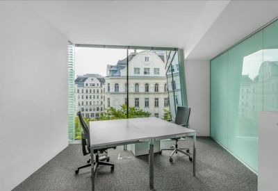 Bright private office with a white desk and frosted glass partition.