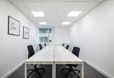 Symmetrical six-person office with white desks and black ergonomic chairs.