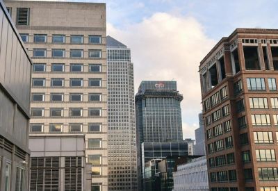 Rooftop terrace overlooking Canary Wharf skyscrapers with glass safety railings.