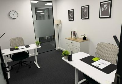 Private two-person office suite with white desks and black chairs.