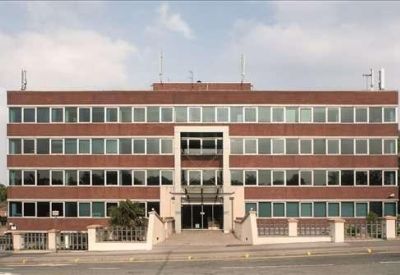 Wide street-side view of the four-story red brick commercial building.