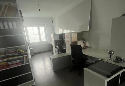 Bright workspace featuring a large whiteboard, tall shelving, and integrated desks.