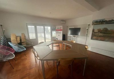 Meeting room with modular trapezoidal tables arranged in a circle and colorful accent chairs.
