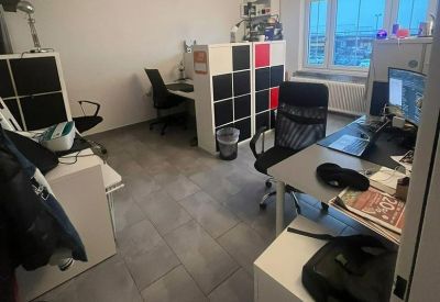 Modern office setup with black mesh chairs and a multi-colored modular partition wall.
