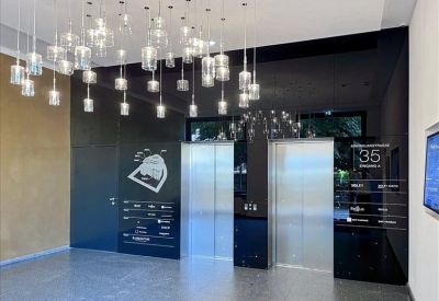 Modern lobby with sleek elevators and decorative hanging pendant lights.