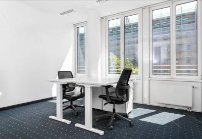 Private office suite with two desks and large windows overlooking the street.
