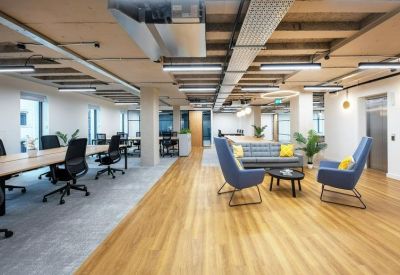 Sunlit communal lounge with comfortable seating areas and indoor plants.