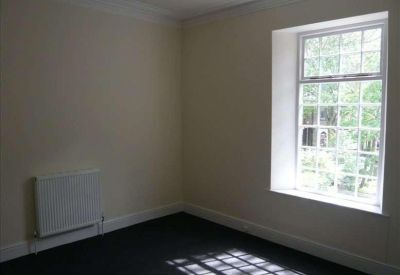 Internal office space featuring a large multi-pane window and wall-mounted radiator.