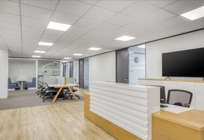 Reception area featuring a white slatted desk, wooden flooring, and a large wall-mounted monitor.