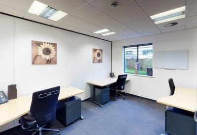 Private three-desk office suite with white partitions and sunflower wall art.