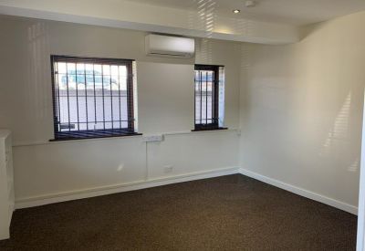 Small office room with air conditioning and twin windows.