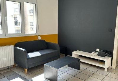 Modern lounge area with a dark grey sofa and a black minimalist coffee table.