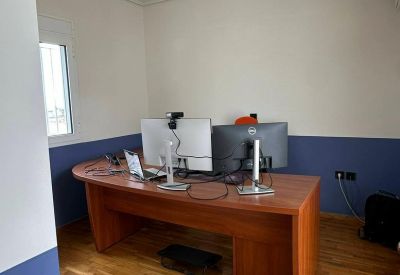 Private office suite with a large wooden desk and natural wood flooring.