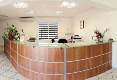 Reception with a curved wooden desk and plants