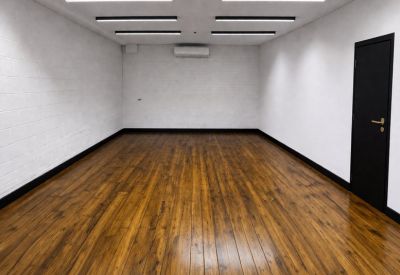 Lengthy workspace showing a black door and air conditioning unit against white walls.