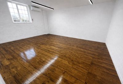 Bright workspace featuring polished wooden floors and white brick walls.