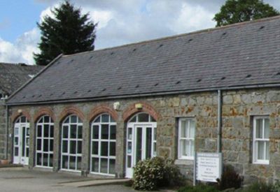 Stone building facade with large arched windows and doors.