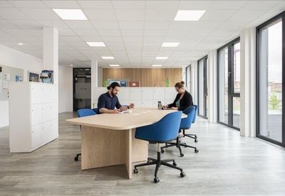 Bright common area with blue chairs and large windows.
