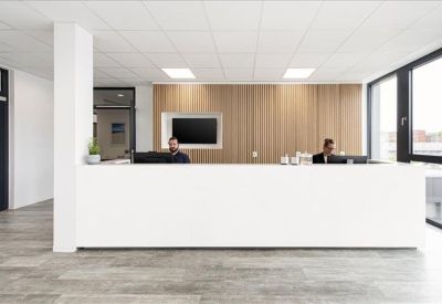 Minimalist white reception desk with wood-paneled feature wall.