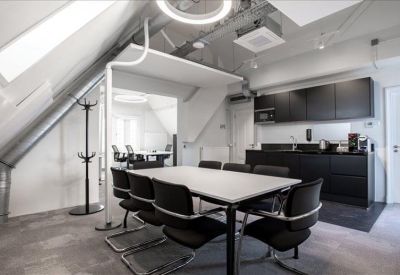 Bright communal kitchen area with a high table and modern cabinetry.