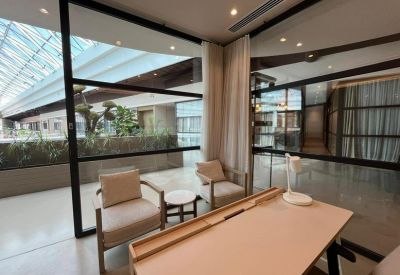 Private glass-walled meeting space with comfortable armchairs and natural light.