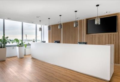Sleek minimalist reception desk with wooden wall panels and pendant lighting.