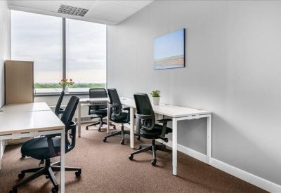 Bright private office suite with four desks and large windows.