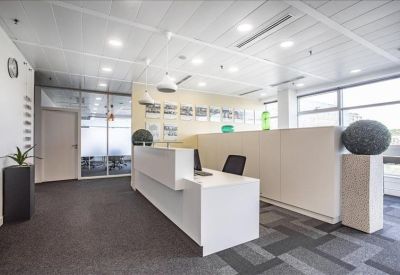 Minimalist reception area with a white desk and decorative stone spheres.