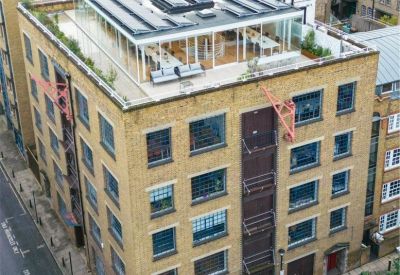 Traditional brick exterior featuring a modern glass-enclosed rooftop extension