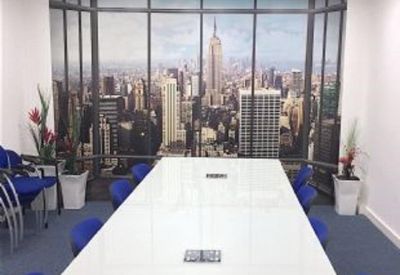 Modern boardroom featuring a white table, blue chairs, and a large New York City skyline wall mural.