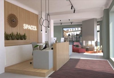 Reception desk with wood paneling and the Spaces logo under modern lighting.