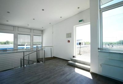 Modern indoor balcony area with glass railings and natural light from large windows.