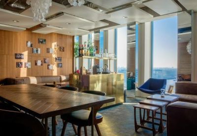 Bright conference room with a large herringbone wood table and panoramic city views.