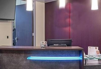 Sleek modern reception area with a dark wood desk and purple accent wall.