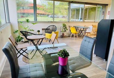 Bright communal lounge with glass tables and colorful seating.